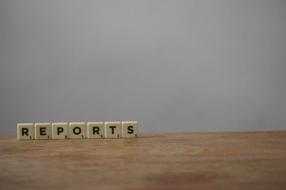 Scrabble tiles spelling 'reports' on a wooden desk, ideal for office or business themes.