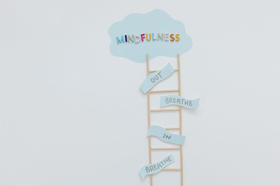 Creative mindfulness concept with ladder, words, and cloud shape for mental well-being.