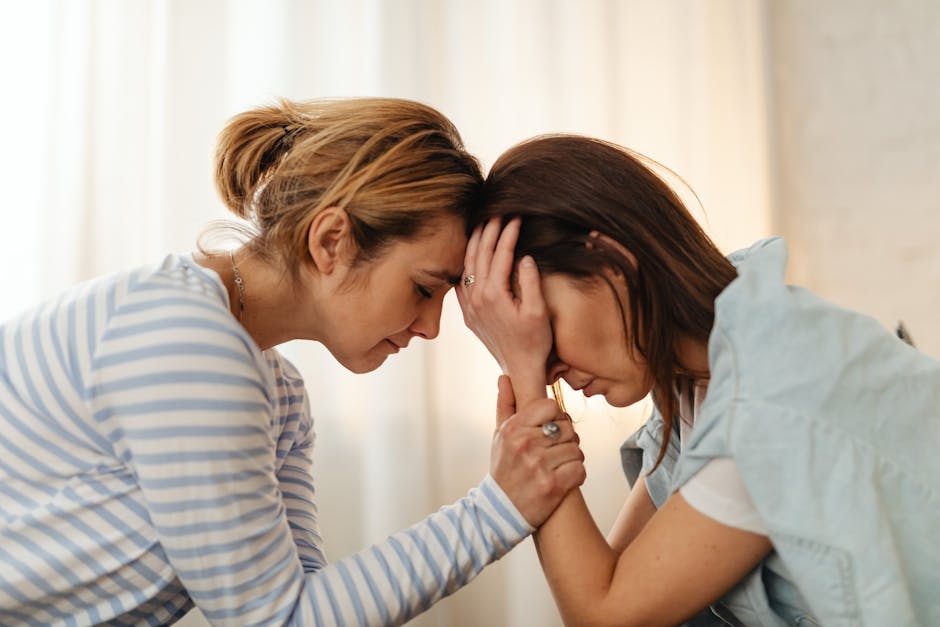 Two women comfort each other in a moment of emotional support indoors.